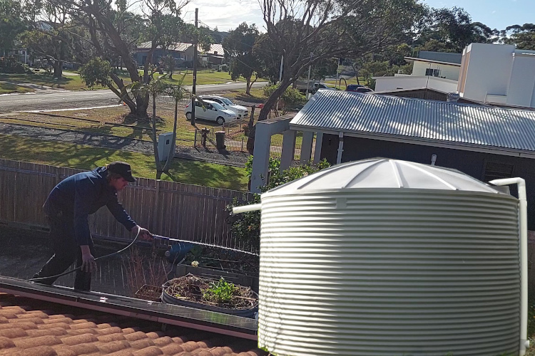 
nowra Gutter Expert Rinses Gutters at Rainwater-Reliant Premises